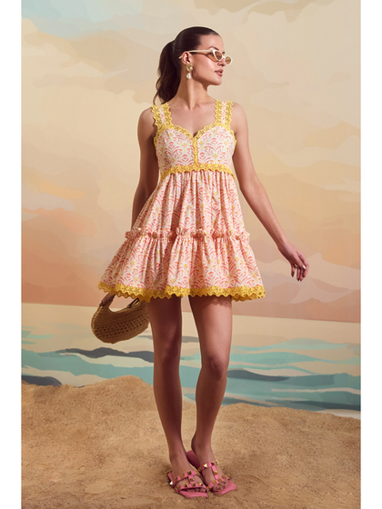 A full-length shot of the Schiffli Sailor Dress from Qala Clothing, styled with a woven bag and sunglasses for a complete summer look.