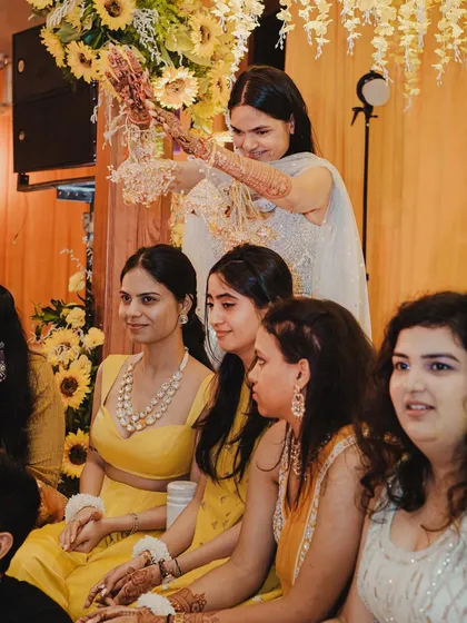 Another angle of the Kaleerein ceremony, showing the bride's friends fully engaged in this cherished tradition.