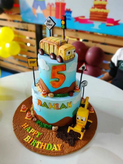 Another angle of the "Stinky & Dirty" cake, showing the textured details on the cake board and the handcrafted sugar figures.