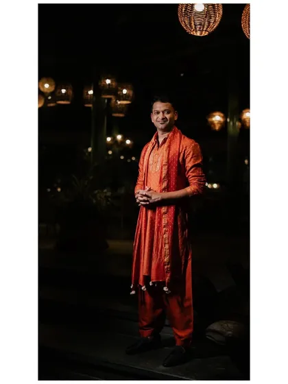 A portrait of the groom in his custom-made orange Patiala set. The vibrant color was a perfect choice for the festive Mehendi night.