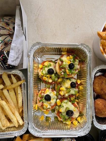 A fun party platter with mini pizzas, french fries, cheese balls, and mini doughnuts.