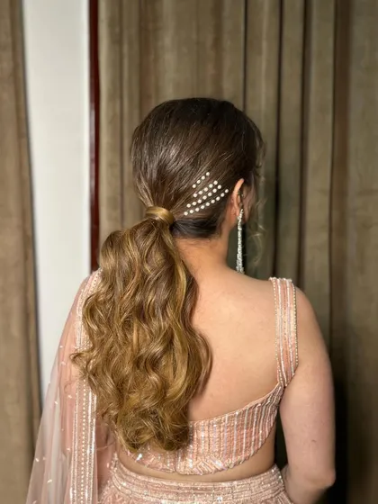 A textured ponytail with a simple pearl hair clip on the side. This is a great example of how a small accessory can elevate a simple hairstyle.