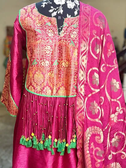 The vibrant colors of this suit set make it a perfect choice for a mehendi or a festive pooja.