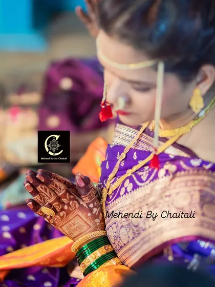 A close-up showing the side profile and the intricate details of the bridal mehendi during the wedding rituals. The makeup remains flawless throughout the long day.
