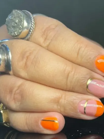 Another view of the colorful orange and pink nail art with gold accents.