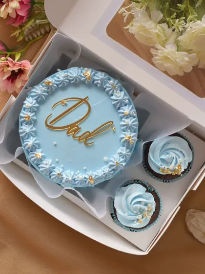 A clean, top-down view of a Father's Day bento cake and cupcake set. The simple piped border on the cake and the gold sprinkles on the cupcakes create an elegant look.