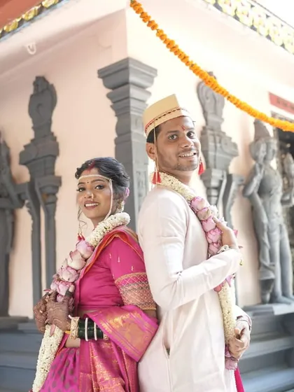 A playful back-to-back pose. The bride's complete look, from makeup to saree draping, is captured beautifully.