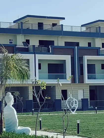 A closer look at the facade of the row housing units in Kanpur. Each unit features a distinct framed balcony and a mix of materials, providing individuality within a cohesive architectural language for the entire community.