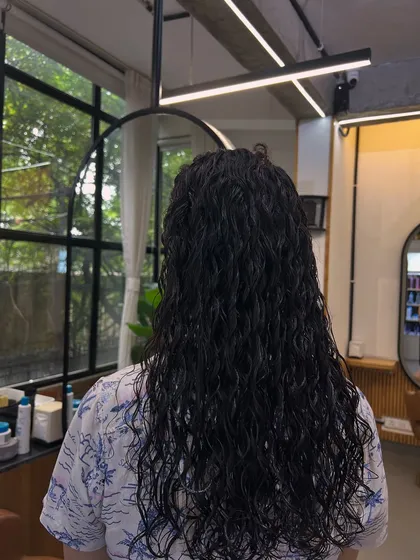 Here is the result of a hair perming service for long hair. The goal was to create uniform, defined, and bouncy curls that add significant volume and a completely new texture from root to tip.