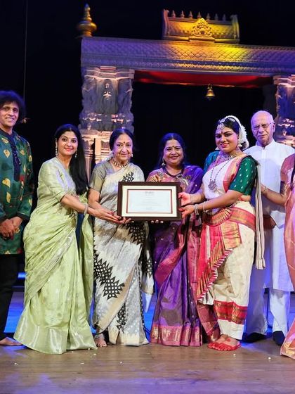 A group of esteemed artists and gurus on stage to bless a young dancer at her Rangapravesha. It is a moment of community and shared tradition, celebrating the continuation of our artistic lineage.