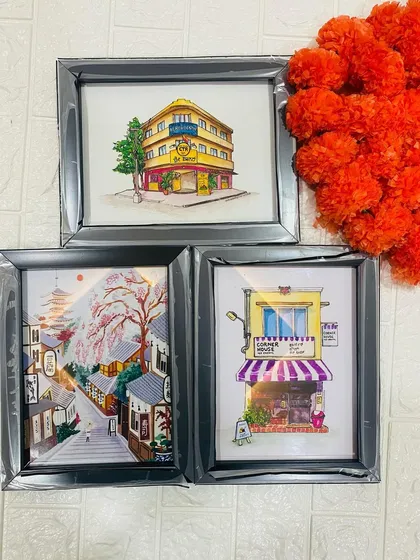 A collection of three framed illustrations, showcasing different artistic styles from architectural drawings to scenic paintings. Each frame is handcrafted to preserve your memories.