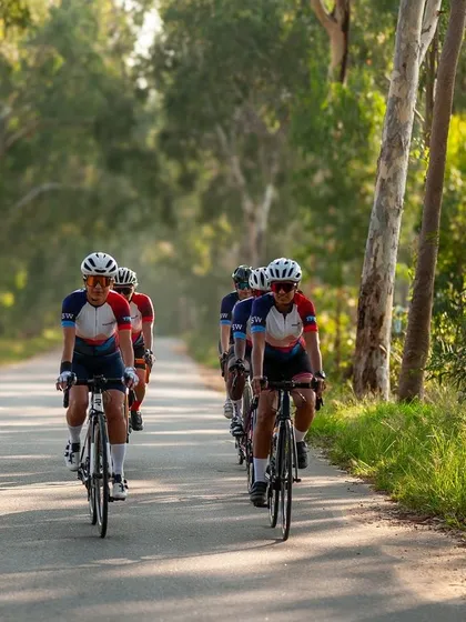 Riding together through a tree-lined avenue. This photo captures the feeling of a perfect day out on the bike with friends, all sporting our custom club apparel.