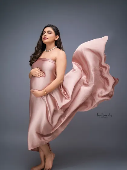 A whisper of satin and a gentle breeze create this stunning, glamorous portrait. The soft pink fabric beautifully complements the mother's radiant glow.