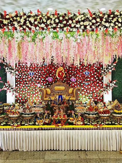 A grand baby shower stage with a backdrop of cascading pink and white flowers, creating a dreamy and romantic atmosphere.