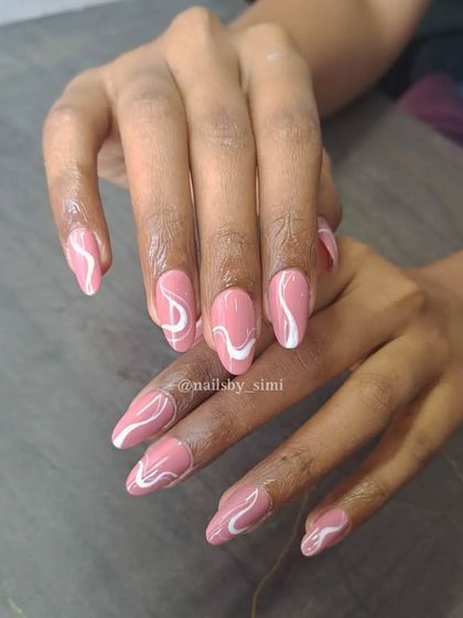 Swirls on a loop! This abstract design with bold white swirls on a dusty pink base is a fun and modern take on nail art.