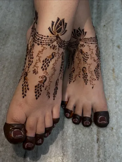 Mehendi for the feet is just as important as for the hands. This design features delicate peacock and floral vines that cascade down the foot, creating an elegant look that resembles beautiful jewelry.