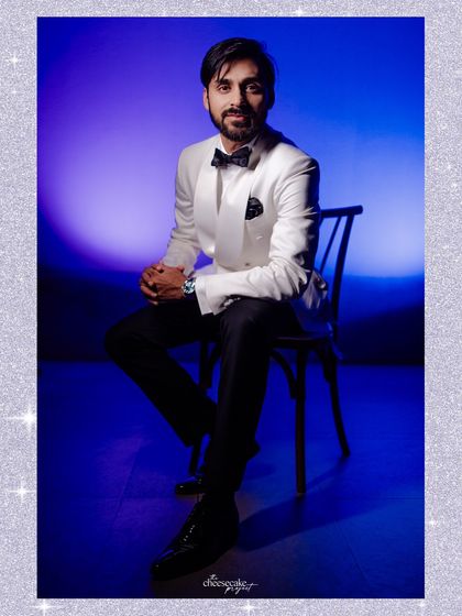 A stylish portrait of the groom against a cool blue backdrop.