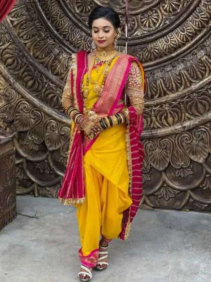 A full-length view of the bride in her yellow and pink Nauvari.