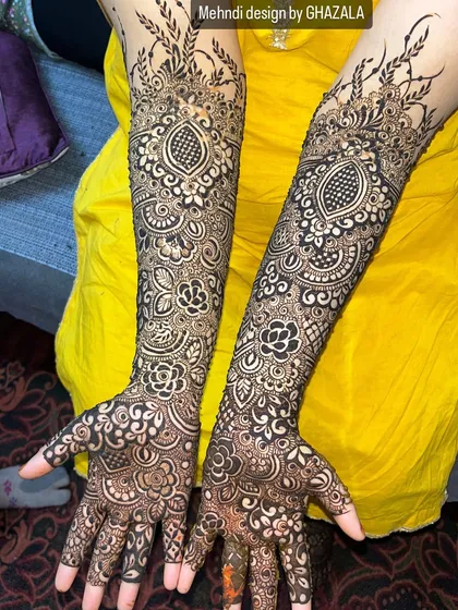 A full-arm bridal design with intricate floral and paisley patterns.