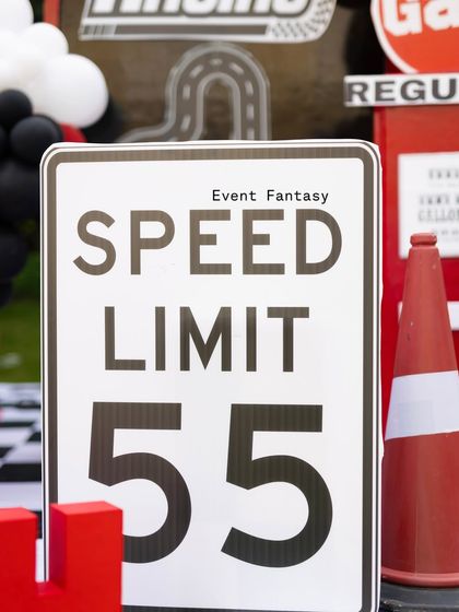 A close-up of the "Speed Limit 55" sign, a fun and thematic detail from the Ferrari party decor.