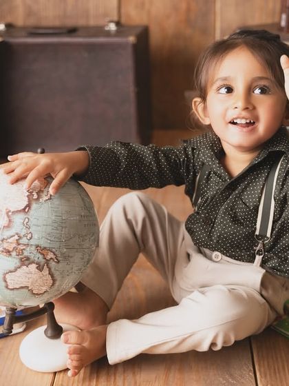 Waving goodbye as he sets off on an imaginary journey. This travel and book-themed shoot is perfect for curious little minds.