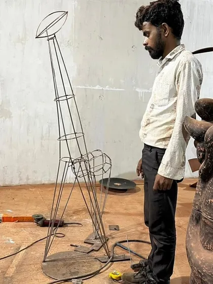 A behind-the-scenes look at the making of the 'Attempts in Value Addition' sculpture. This video shows the artist at work, revealing the metal framework that forms the skeleton of the final wooden piece.