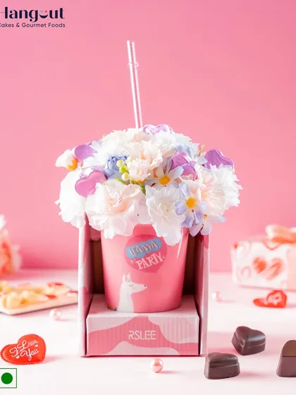 This Valentine's Day hamper includes five heart-shaped almond chocolates in a ceramic sipper decorated with artificial flowers. It's a beautiful arrangement that brings a sense of purity and devotion.