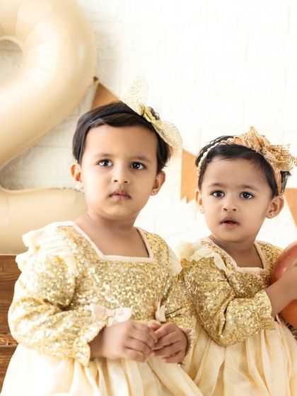 A close-up of the twin girls, showcasing their beautiful matching outfits and sweet expressions.