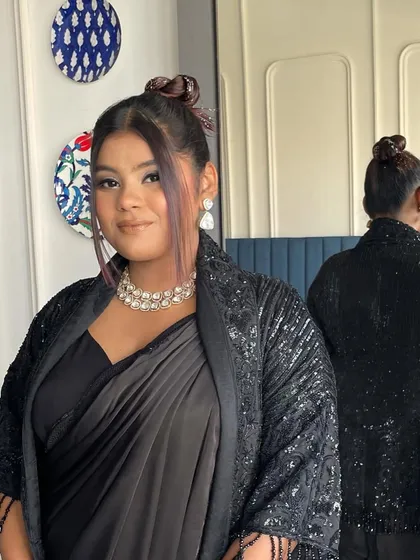 A full look of the client wearing the glitter top knot with a modern saree, proving it's the perfect hairstyle for a contemporary Indian look.