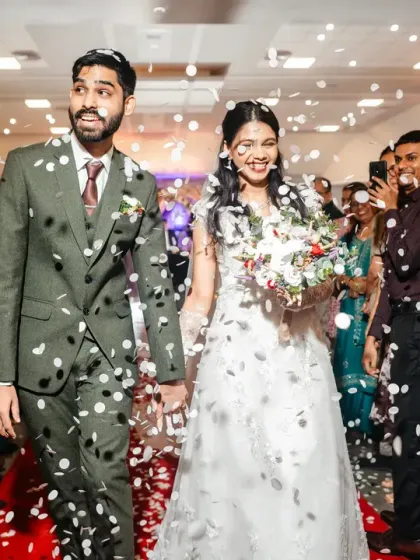 That "just married" feeling! The couple makes their exit from the ceremony, showered in confetti by their cheering friends and family.