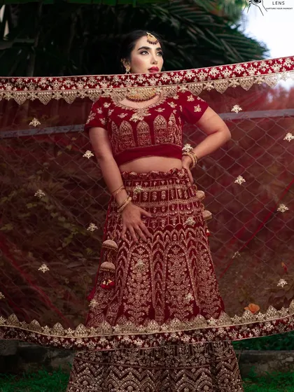 A creative shot using the bridal dupatta to frame her face. This highlights the flawless makeup and the rich colour of her outfit.