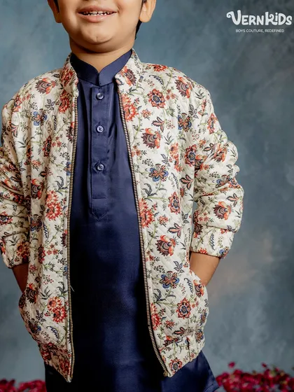 A perfect fusion look. Our off-white floral bomber jacket layered over a navy blue kurta set creates a sophisticated and modern ethnic outfit.