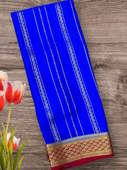 A stunning royal blue pure crepe Mysore silk saree with silver and gold stripes, paired with a rich red border.