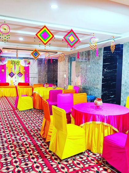 Another perspective of the Mehendi hall, highlighting the colourful seating and the traditional hangings that fill the space.