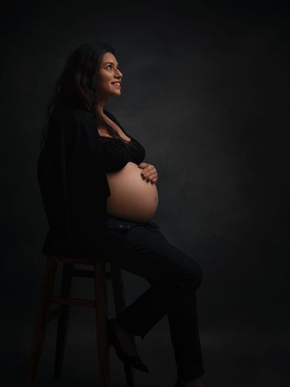A powerful and confident portrait of a mom-to-be in a modern, edgy style. The dramatic lighting creates a beautiful fine art look.