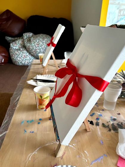 Canvases prepped with a red ribbon for our Valentine's paint date, adding a special touch to the experience before the first brushstroke.