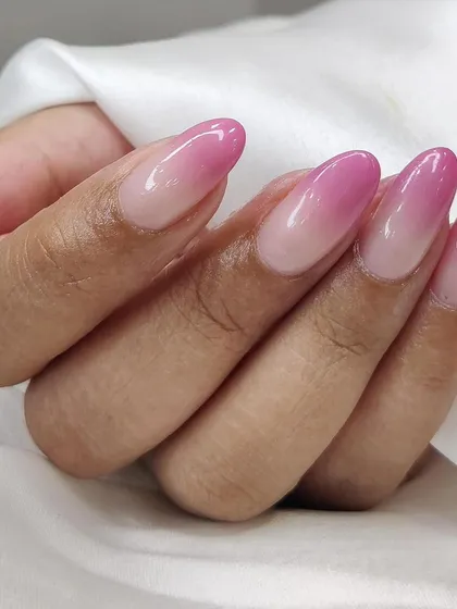 A side view of the bright pink ombré, highlighting the flawless color gradient on these almond nails.