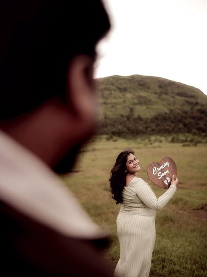 An artistic shot taken over the shoulder of the dad-to-be, focusing on his partner as she smiles back at him. It creates a sense of intimacy and a shared secret.