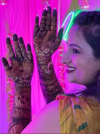 Another beautiful shot of a bride posing in front of a neon sign at her mehendi party.