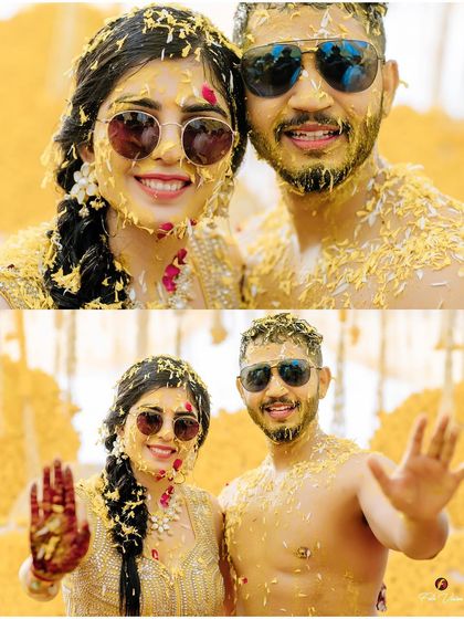 The happy couple, covered in turmeric and flower petals, posing for a fun selfie style shot. Their sunglasses add a cool, modern twist to the traditional ceremony.