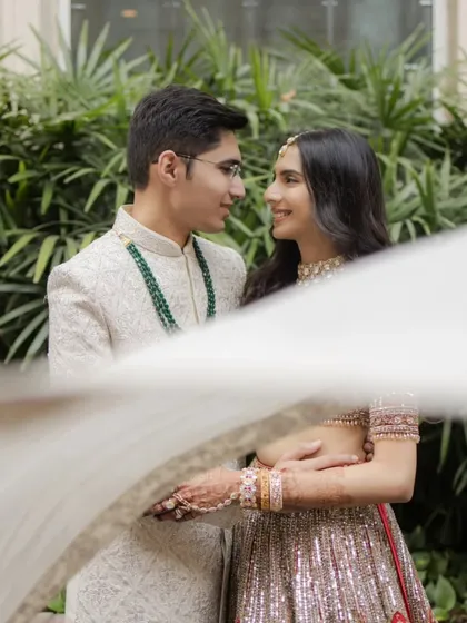 An artistic shot of the couple seen through a flowing white cloth, creating a dreamy, romantic, and intimate portrait.