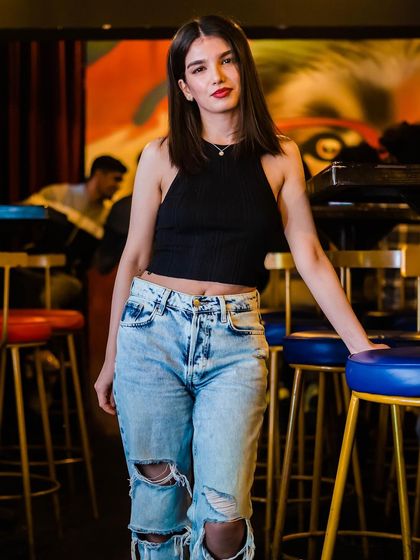 A guest in ripped jeans and a black top, looking cool and casual.