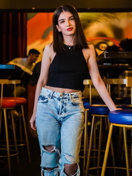 A guest in ripped jeans and a black top, looking cool and casual.