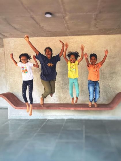 Children joyfully jumping on a floating bench, a moment that perfectly captures the spirit of the home. I design spaces and furniture to be not just looked at, but to be actively and happily used by the whole family.