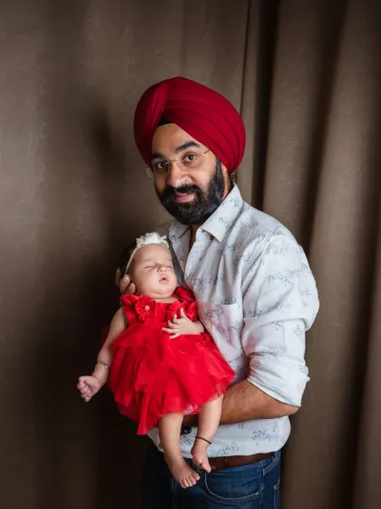 A proud father holds his sleeping daughter, his whole world in his arms. This simple, heartfelt portrait showcases the strength and tenderness of a dad's love.
