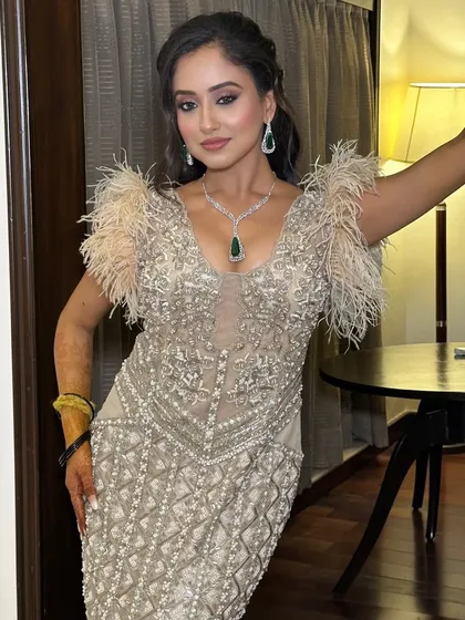 Stunning in a feather gown for her cocktail night. The makeup is a soft glam with a smoked liner and blushed tones to complement the drama of the outfit.