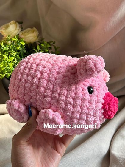 Holding our handmade crochet pig. We use high-quality, eco-friendly materials to ensure our toys are safe and sustainable.