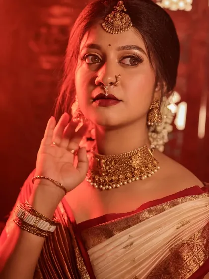 A close-up portrait with intense red lighting, creating a bold and dramatic mood. The bride's expression is strong and captivating.