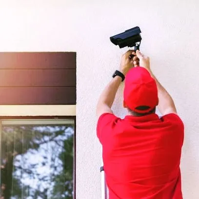 An outdoor camera installation in progress. Our technicians are equipped to work at heights and on various exterior surfaces to place cameras exactly where they are needed for maximum security.