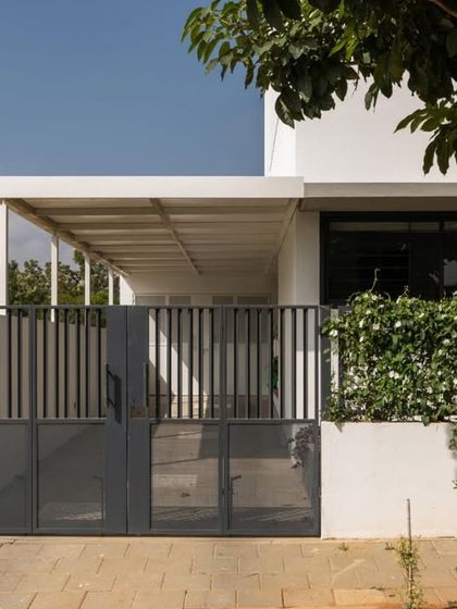 The entrance gate and veranda, showcasing the clean lines and functional design. The covered veranda provides a shaded transition space, protecting the interior from direct sun and rain.